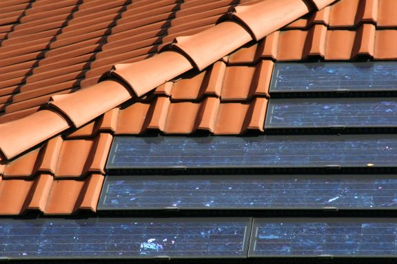 PV-Anlagen Dach mit roten Ziegeln und Solarplatten.