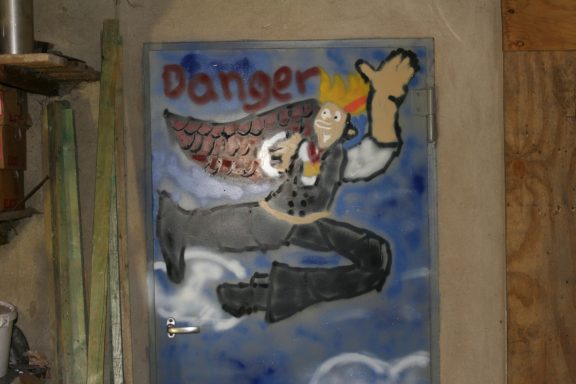 Graffiti Graffiti mit einem fliegenden Mann und dem Wort "Danger" in bunten Farben.