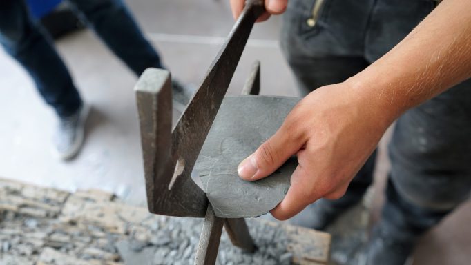 Naturschiefer Naturschieferbearbeitung mit Hammer und Haubrücke